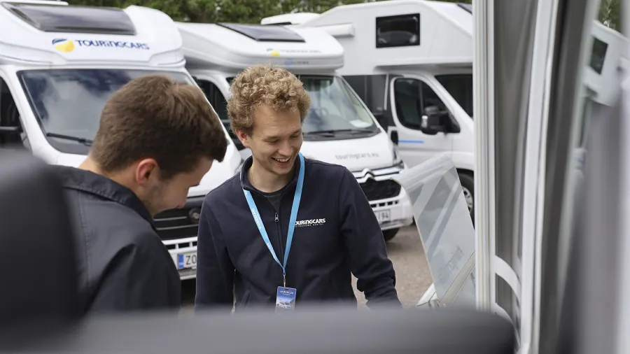 touring cars employees in front of motorhomes